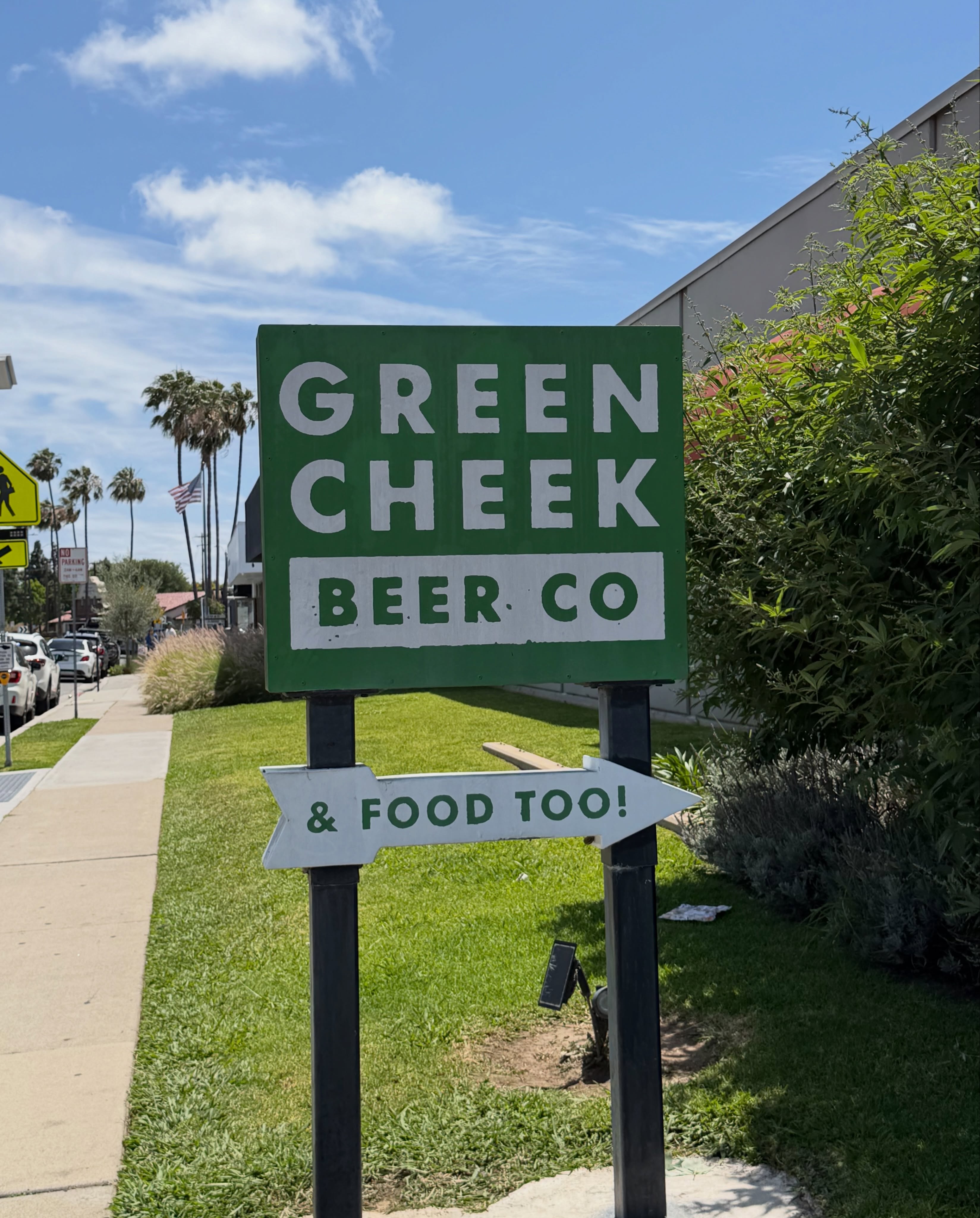 Green Cheek Beer Co. Costa Mesa店の緑の看板とヤシの木