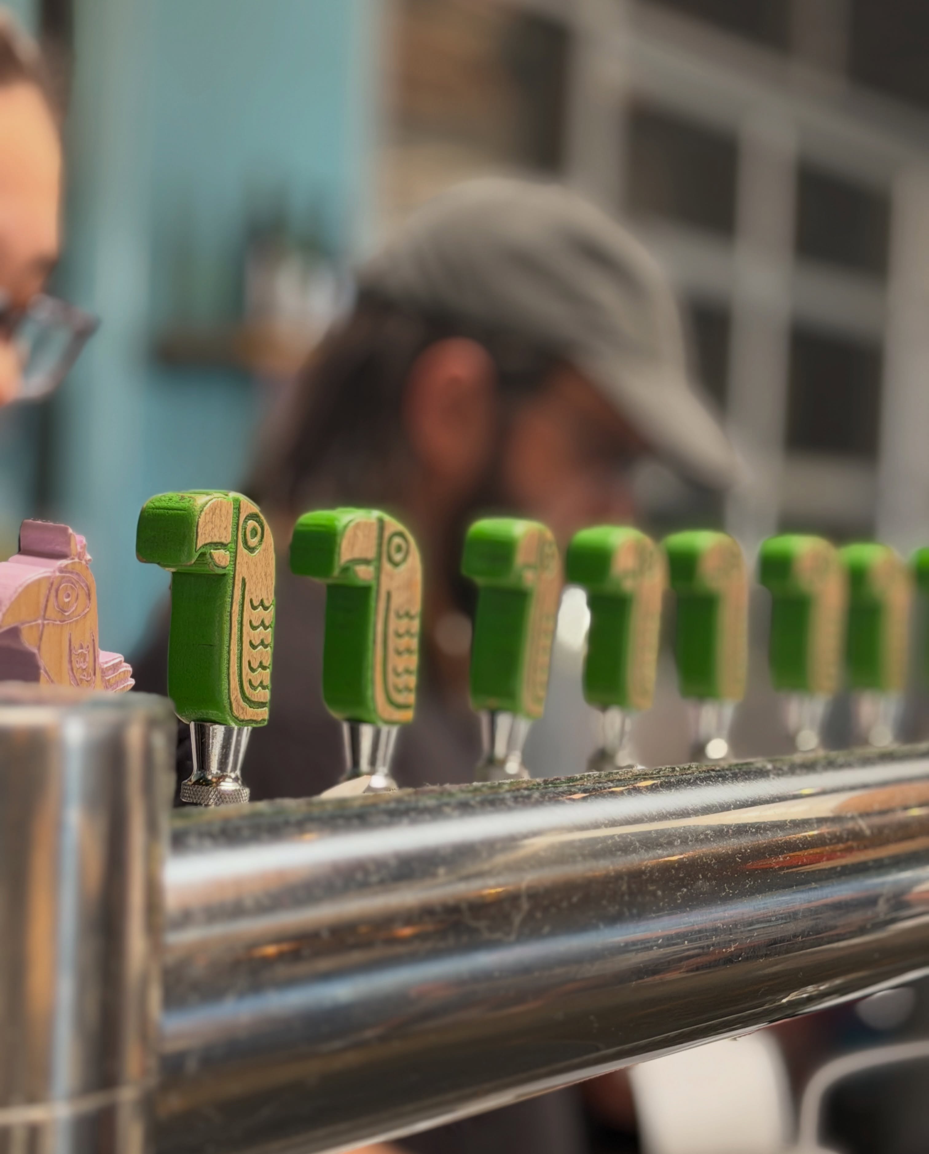 Green Cheek Beer Co.カウンターの緑色の鳥型タップハンドル
